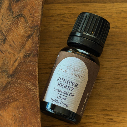 Bottle of Juniper Berry essential oil on a wooden surface