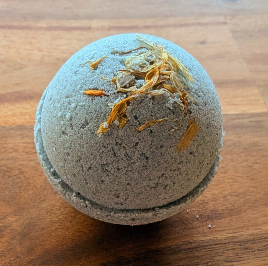 Bath bomb with gold flakes on a wooden surface